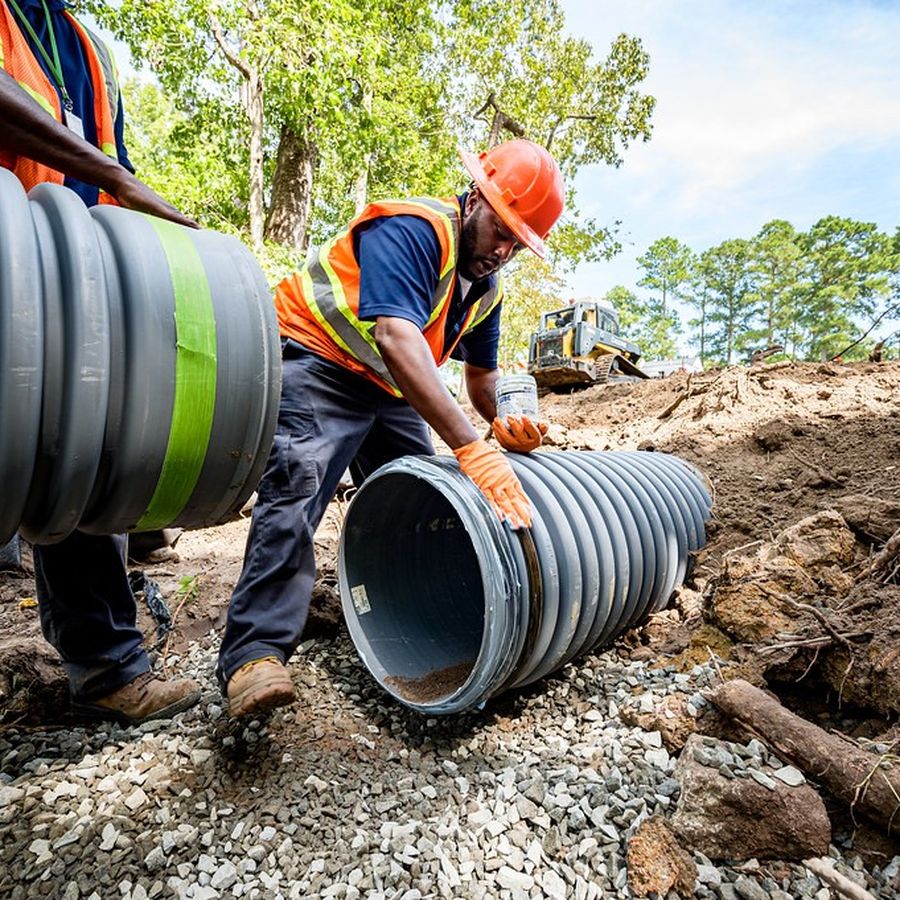 Worker installing a sewer and drain pipe